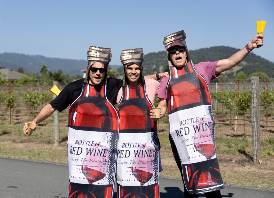 Three runners dressed as bottles of red wine