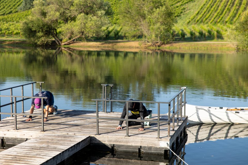 Runners stretching on a lake deck before the start